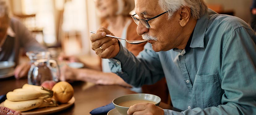 an elderly man enjoying a meal